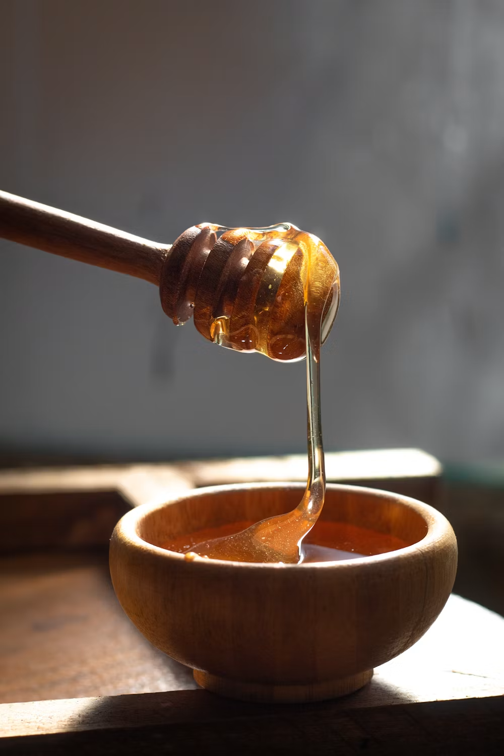Jar of raw honey with a wooden dipper
